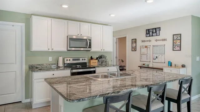 a kitchen with granite countertop a stove and cabinets