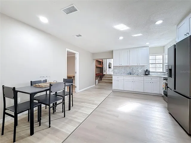 a kitchen with refrigerator and chairs