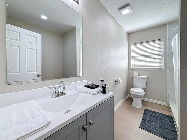 a bathroom with a sink a toilet and shower