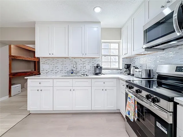 a view of an entryway with wooden floor and kitchen view