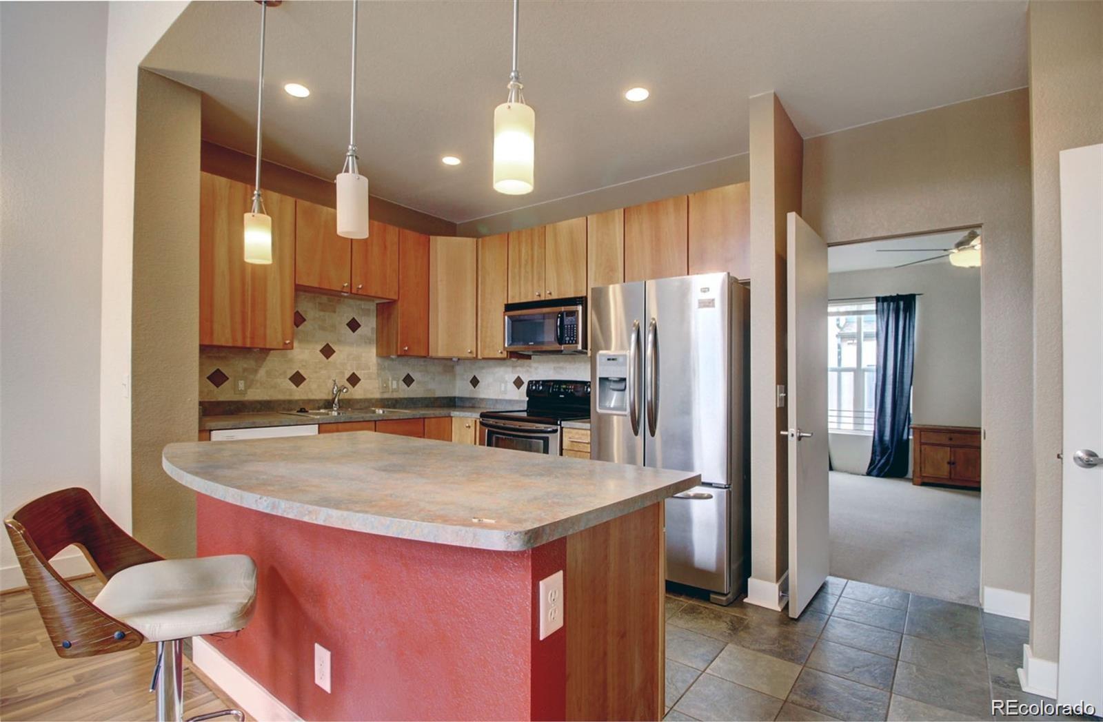 2360 South Wheeling Circle Aurora, CO 80014 - Photo 3 of 26 a kitchen with kitchen island a refrigerator and a stove