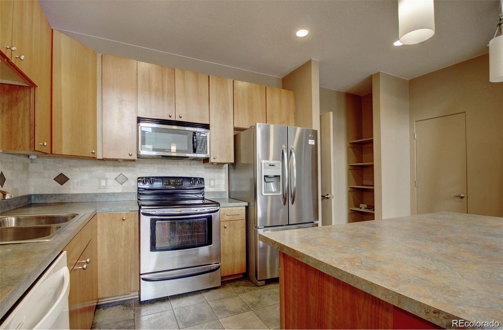 2360 South Wheeling Circle Aurora, CO 80014 - Photo 4 of 26 a kitchen with a sink stove and refrigerator