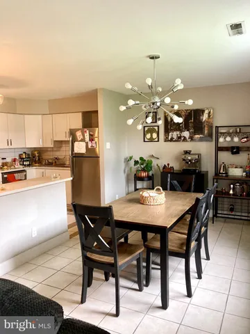 a dining area with a table chairs and a kitchen view