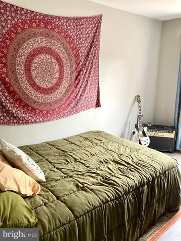 a bedroom with a bed and a painting on the wall