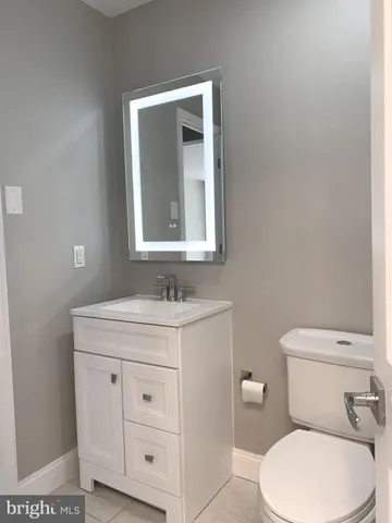 a bathroom with a toilet a sink a vanity and mirror