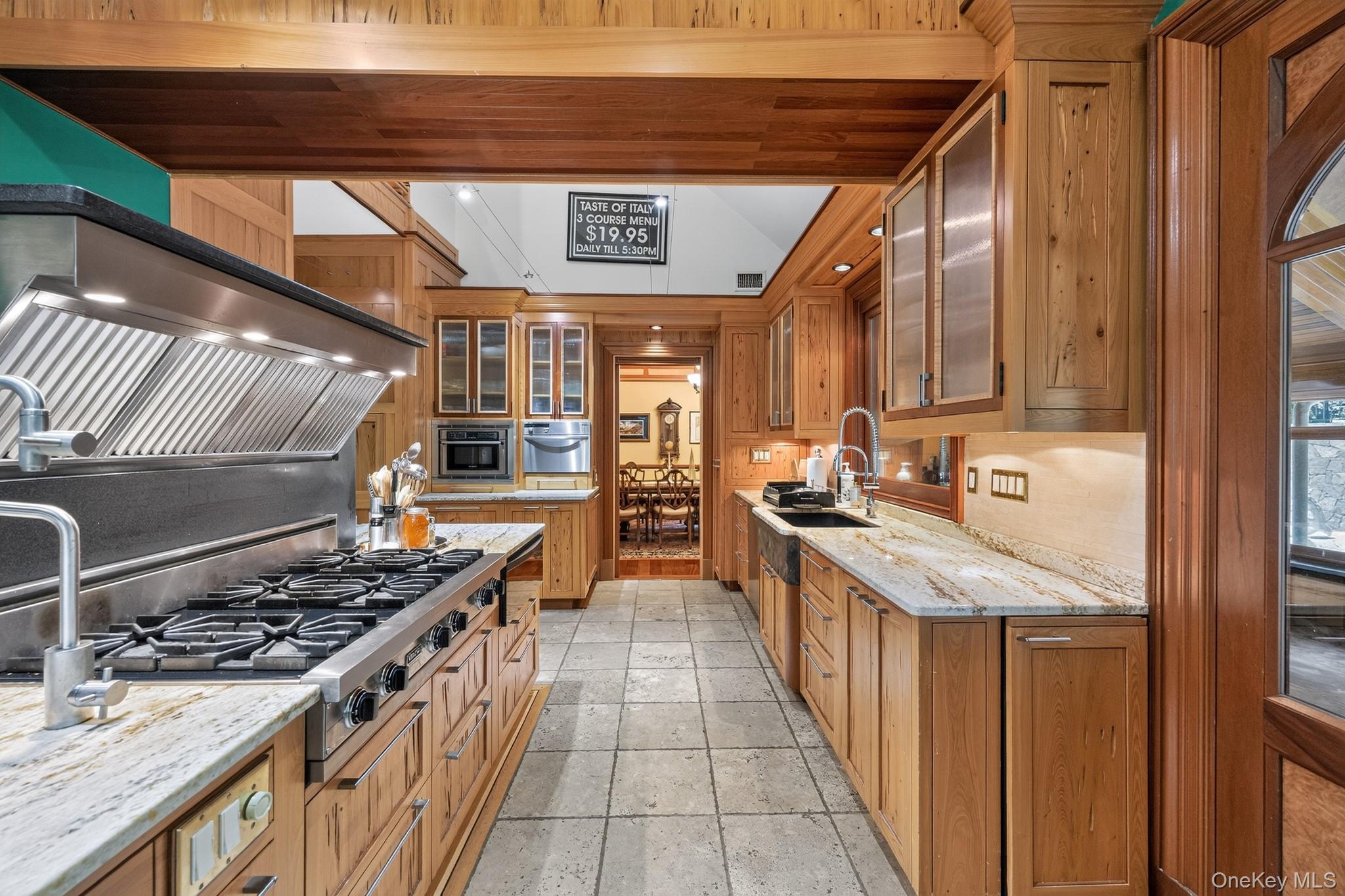 23 Inningwood Road Ossining, NY 10562 - Photo 16 of 50 Gourmet kitchen featuring a commercial-grade range with a stainless steel vent hood, extensive wood cabinetry, stone countertops, and tile flooring