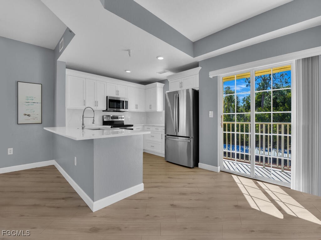 4500 Botanical Pl Circle, Unit 307 Naples, FL 34112 - Photo 4 of 43 a kitchen with stainless steel appliances a refrigerator and a stove top oven