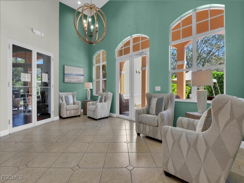 4500 Botanical Pl Circle, Unit 4 Naples, FL 34112 - Photo 41 of 43 a living room with furniture a chandelier and a large window