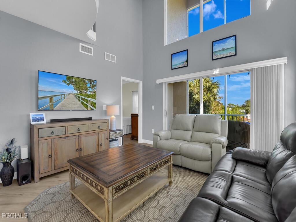 4500 Botanical Pl Circle, Unit 307 Naples, FL 34112 - Photo 6 of 43 a living room with furniture and a flat screen tv