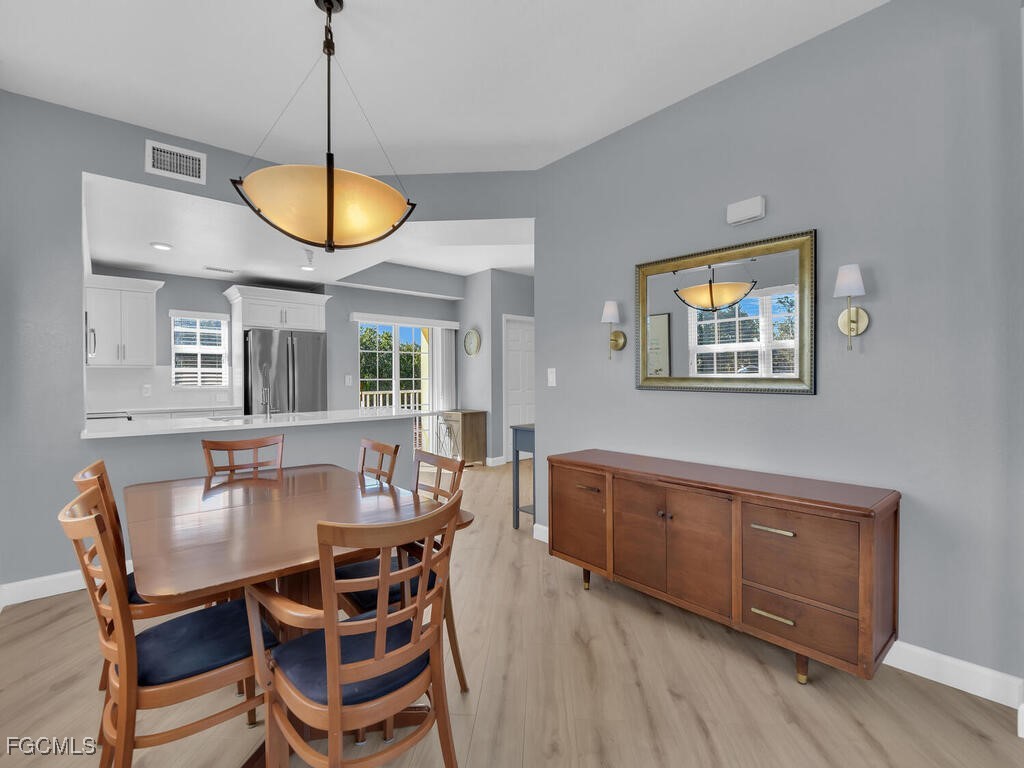 4500 Botanical Pl Circle, Unit 307 Naples, FL 34112 - Photo 7 of 43 a view of a dining room with furniture and chandelier