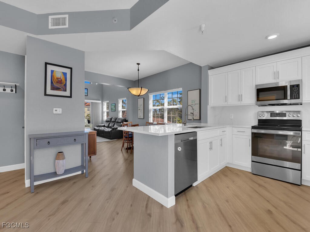 4500 Botanical Pl Circle, Unit 4 Naples, FL 34112 - Photo 8 of 43 a kitchen with a refrigerator and a stove top oven