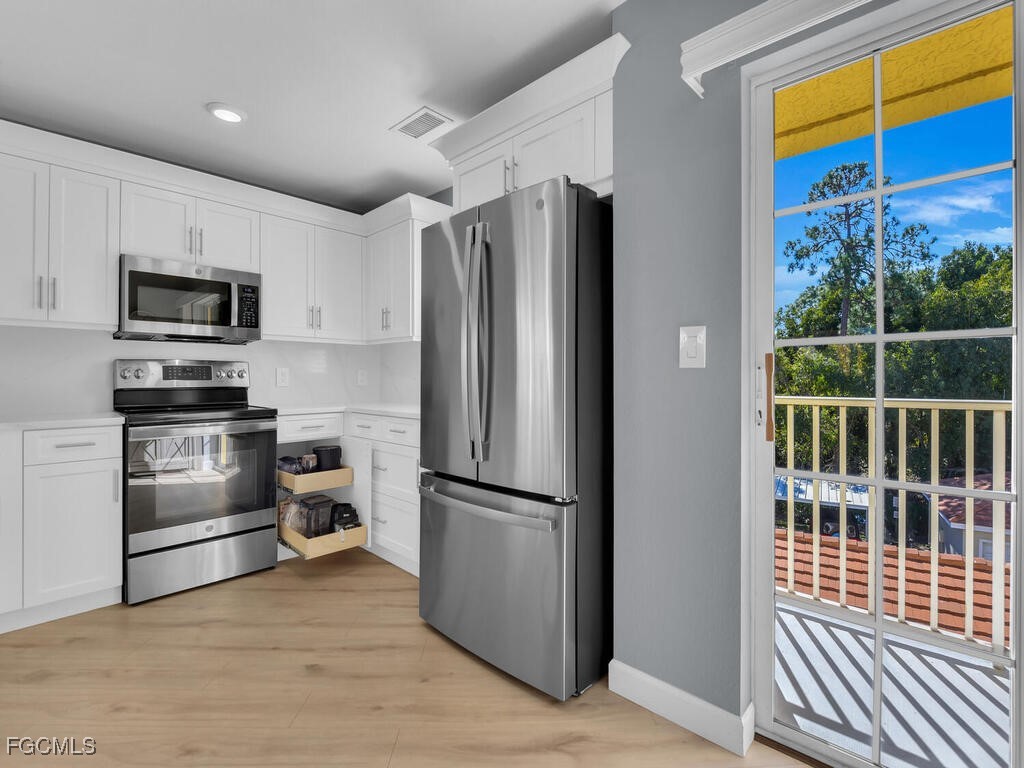 4500 Botanical Pl Circle, Unit 307 Naples, FL 34112 - Photo 9 of 43 a kitchen with stainless steel appliances a refrigerator and a microwave