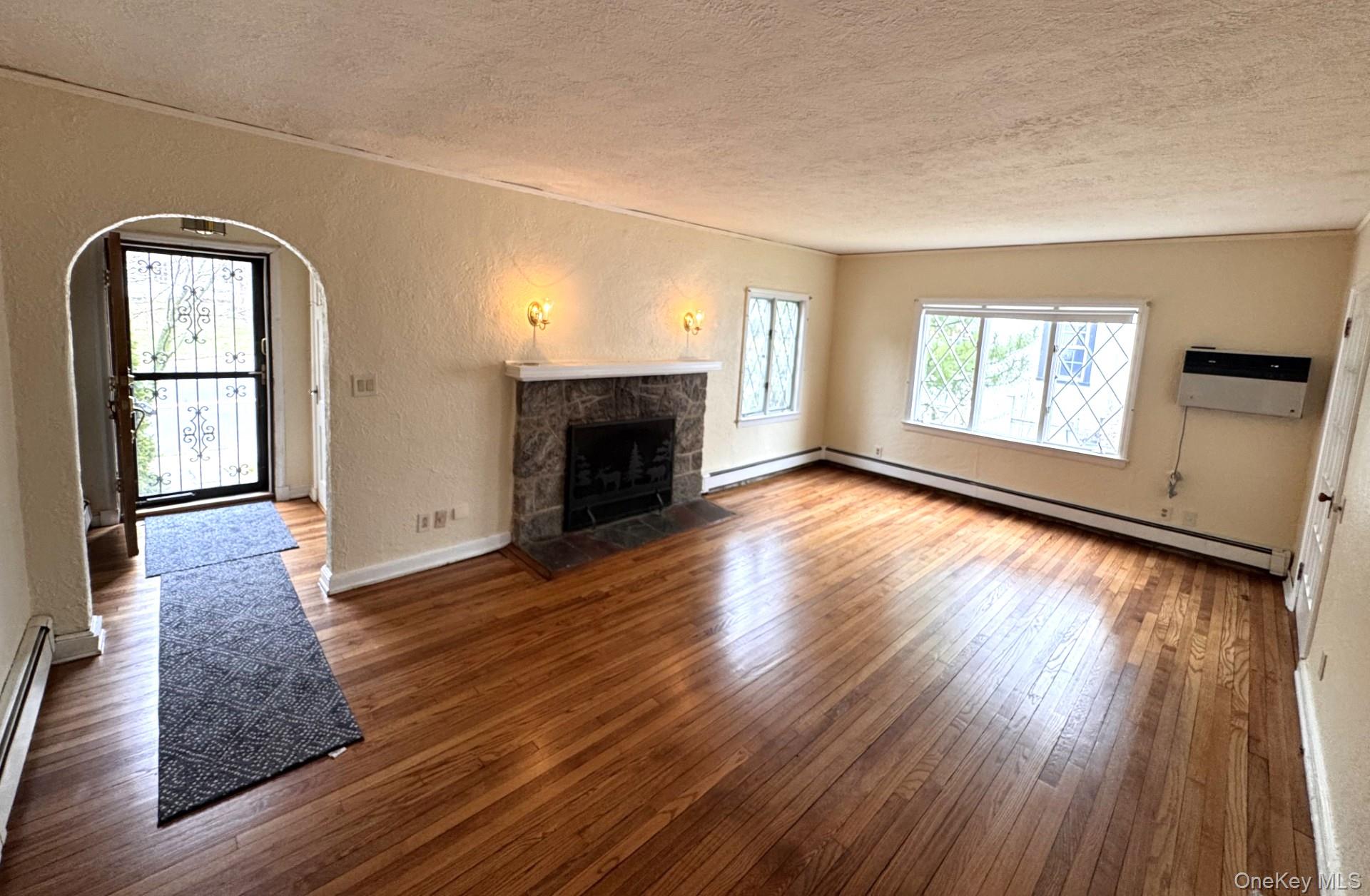 444 Milton Road Rye, NY 10580 - Photo 2 of 23 an empty room with windows fireplace and wooden floor