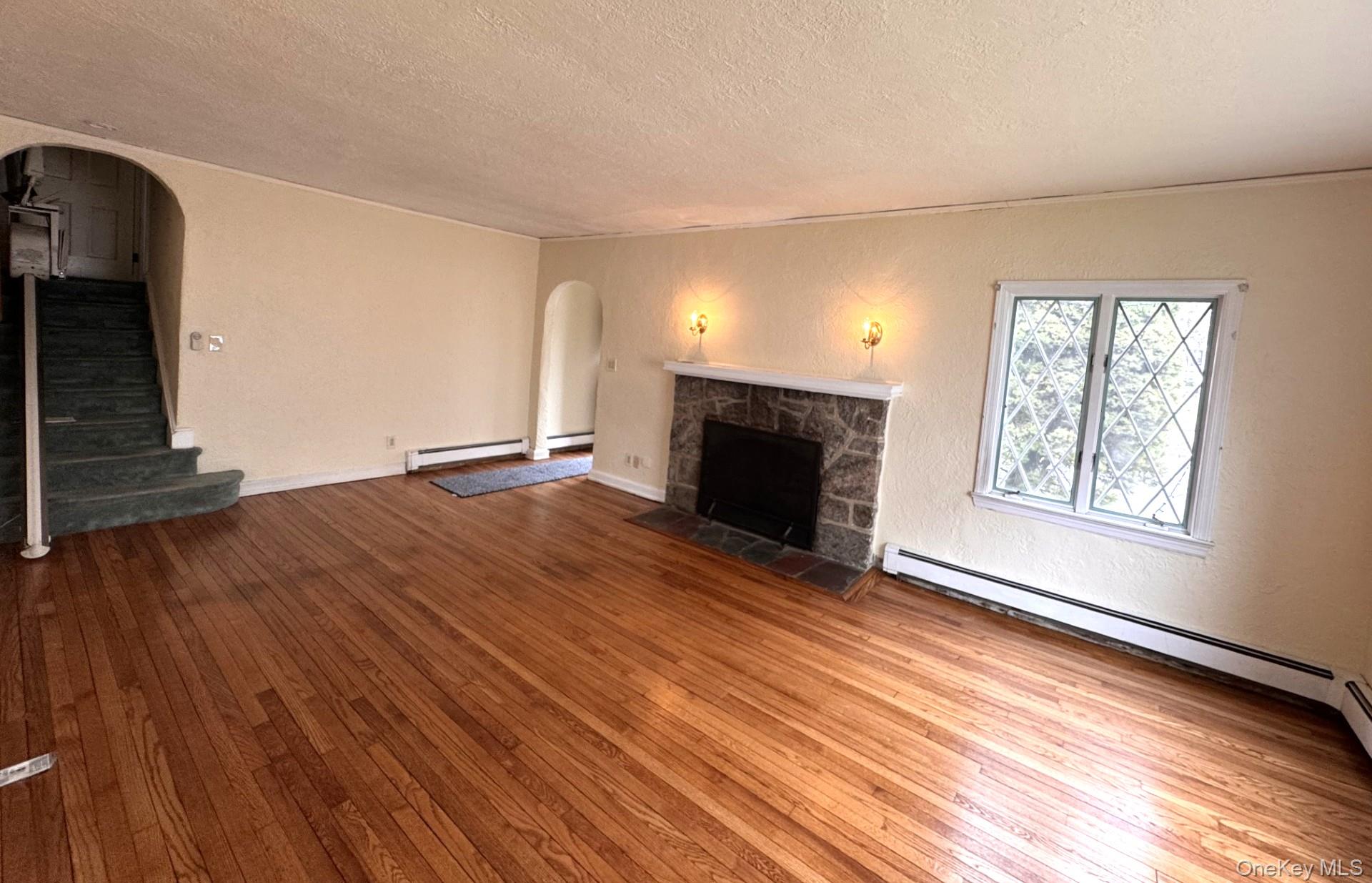 444 Milton Road Rye, NY 10580 - Photo 3 of 23 a view of an empty room with wooden floor fireplace and a window