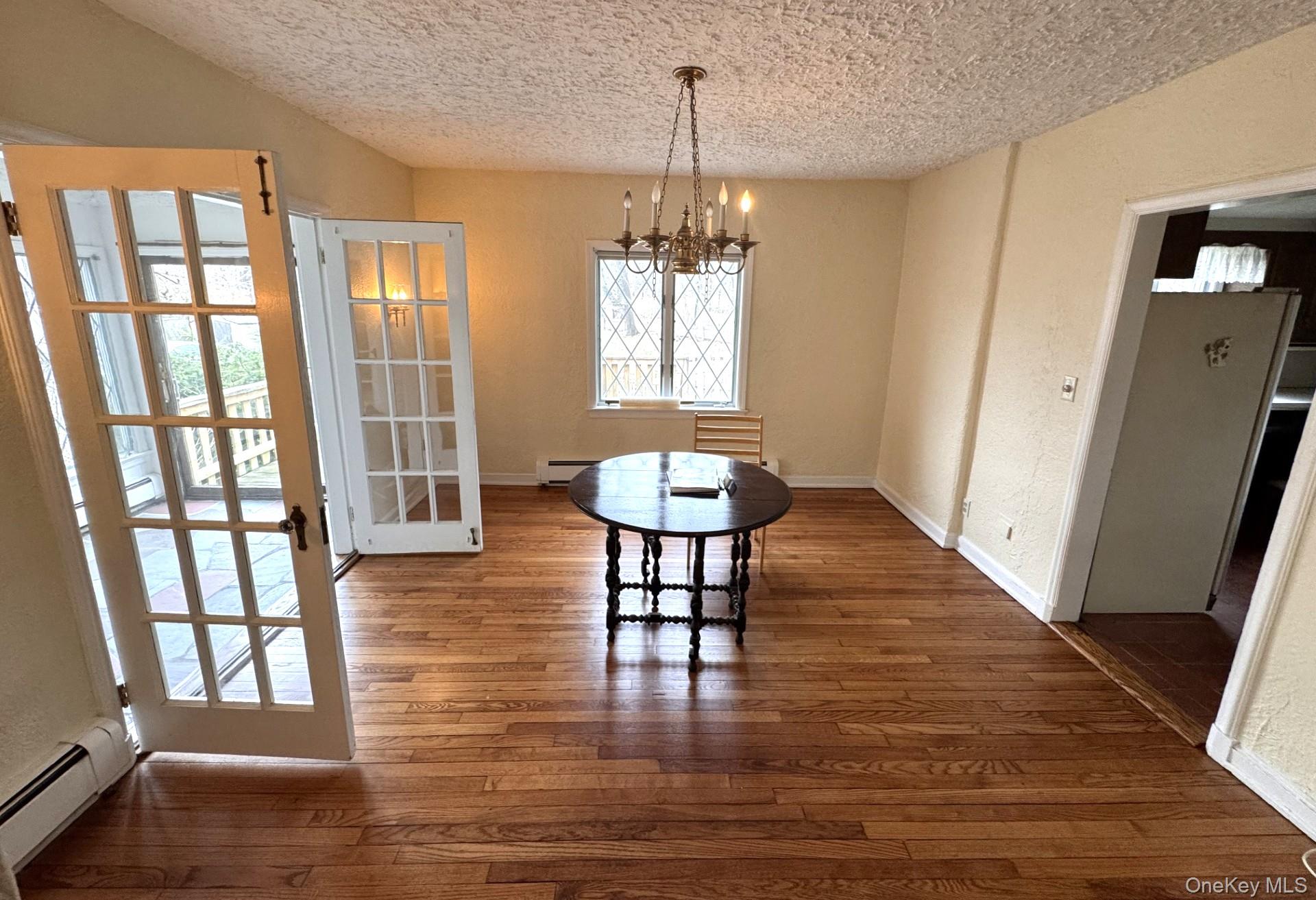 444 Milton Road Rye, NY 10580 - Photo 4 of 23 a dining room with wooden floor and a chandelier