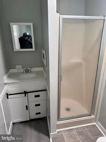 a bathroom with a granite countertop sink a mirror and shower