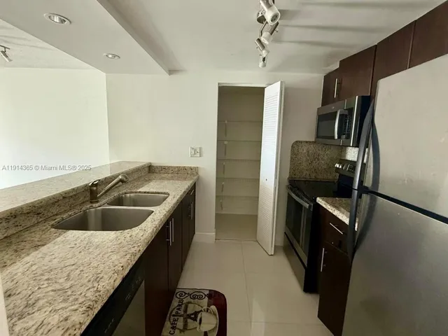 a kitchen with kitchen island a sink stove and refrigerator