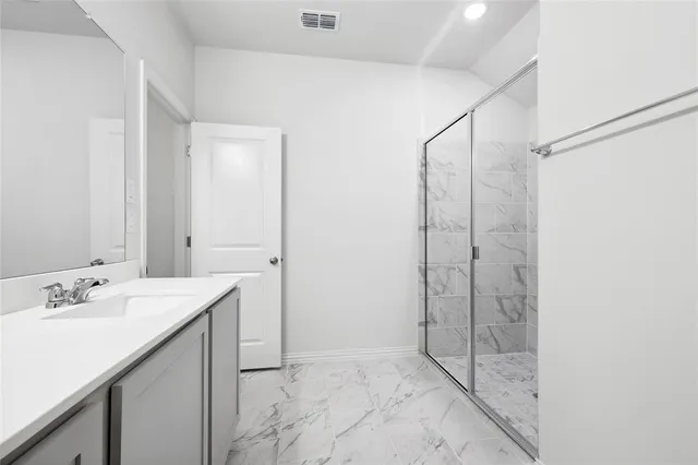 a bathroom with a shower sink and mirror