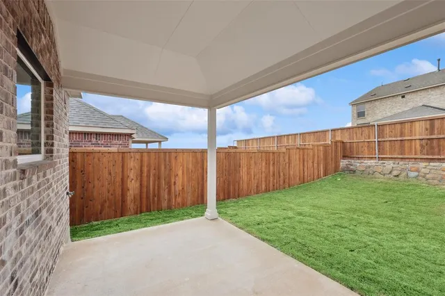 a view of a backyard with wooden fence