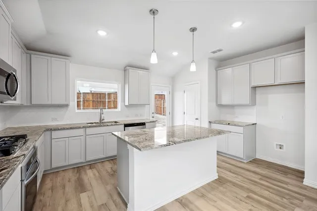 a kitchen with a sink stove and cabinets