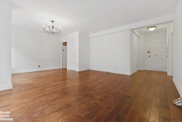 a view of empty room with wooden floor and window