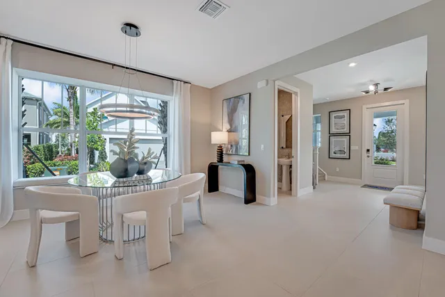 a kitchen with stainless steel appliances a refrigerator a sink dishwasher with a dining table and chairs