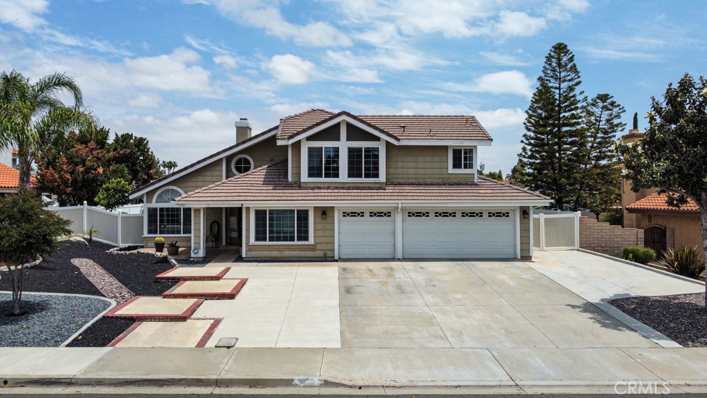a front view of a house with a garden and trees