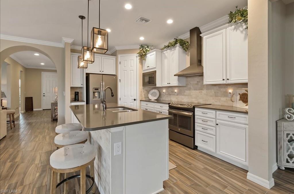 10809 Dennington Road Fort Myers, FL 33913 - Photo 13 of 30 a kitchen with stainless steel appliances granite countertop a sink a stove and a refrigerator