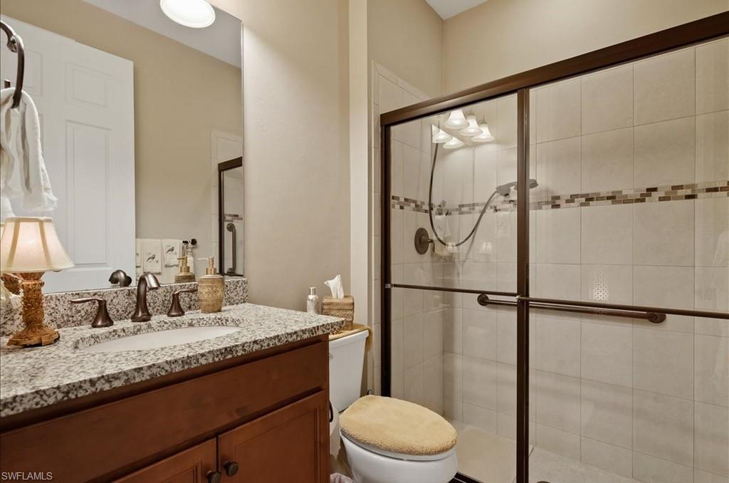 10809 Dennington Road Fort Myers, FL 33913 - Photo 21 of 30 a bathroom with a granite countertop sink mirror vanity and toilet
