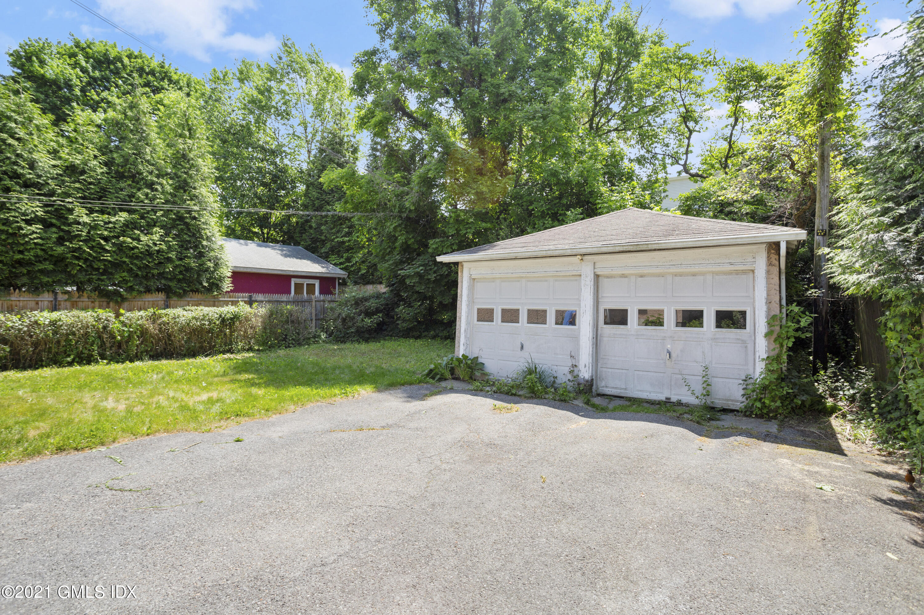 53 Richland Road Greenwich, CT 06830 - Photo 15 of 20 a view of house next to a yard with potted plants and big trees