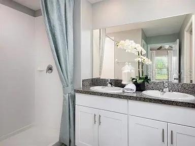 35008 Ackley Trace Zephyrhills, FL 33541 - Photo 9 of 11 a bathroom with a granite countertop sink and a mirror