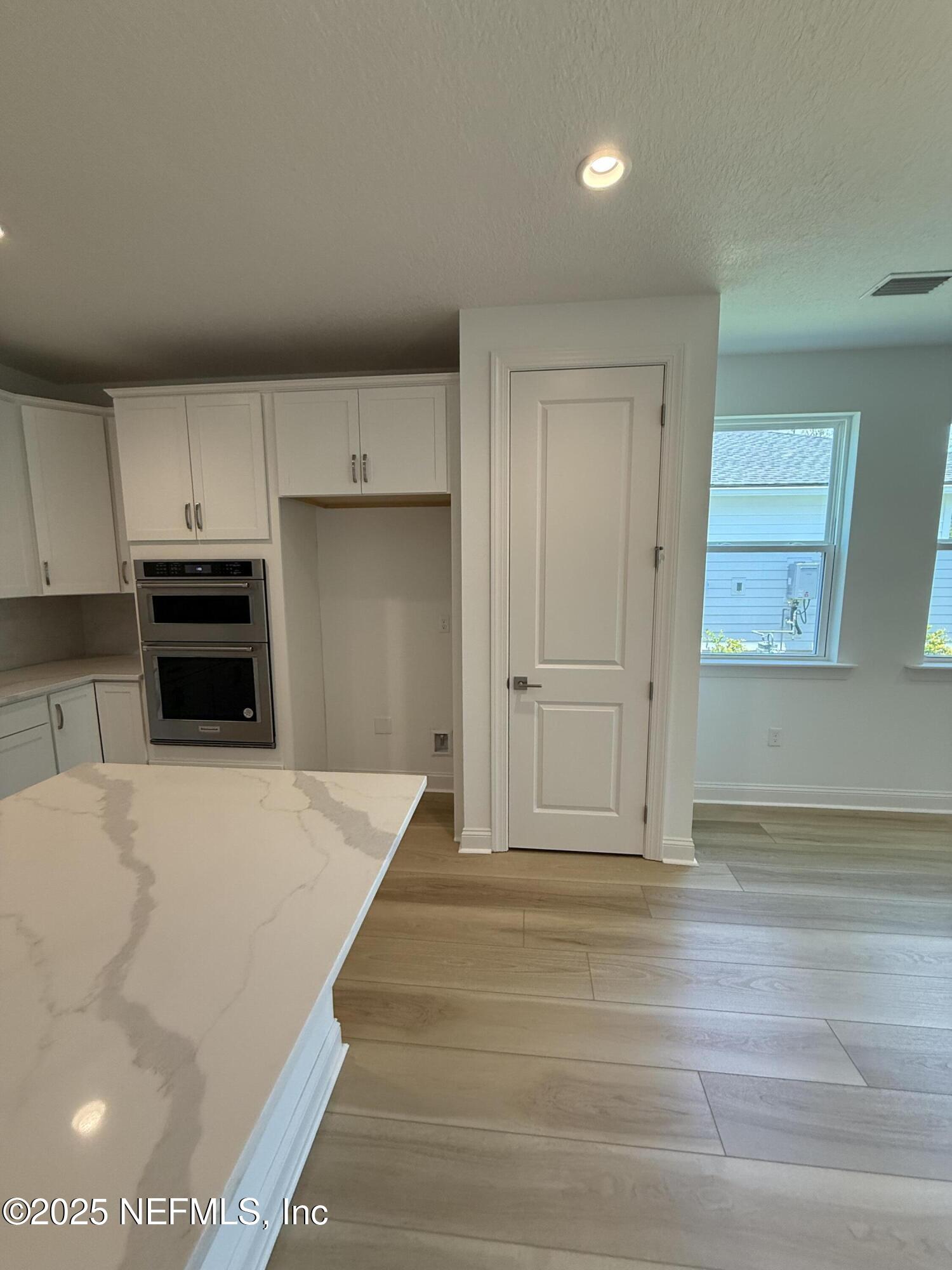 34 Mulberry Road Palm Coast, FL 32164 - Photo 28 of 63 a view of kitchen and empty room with wooden floor