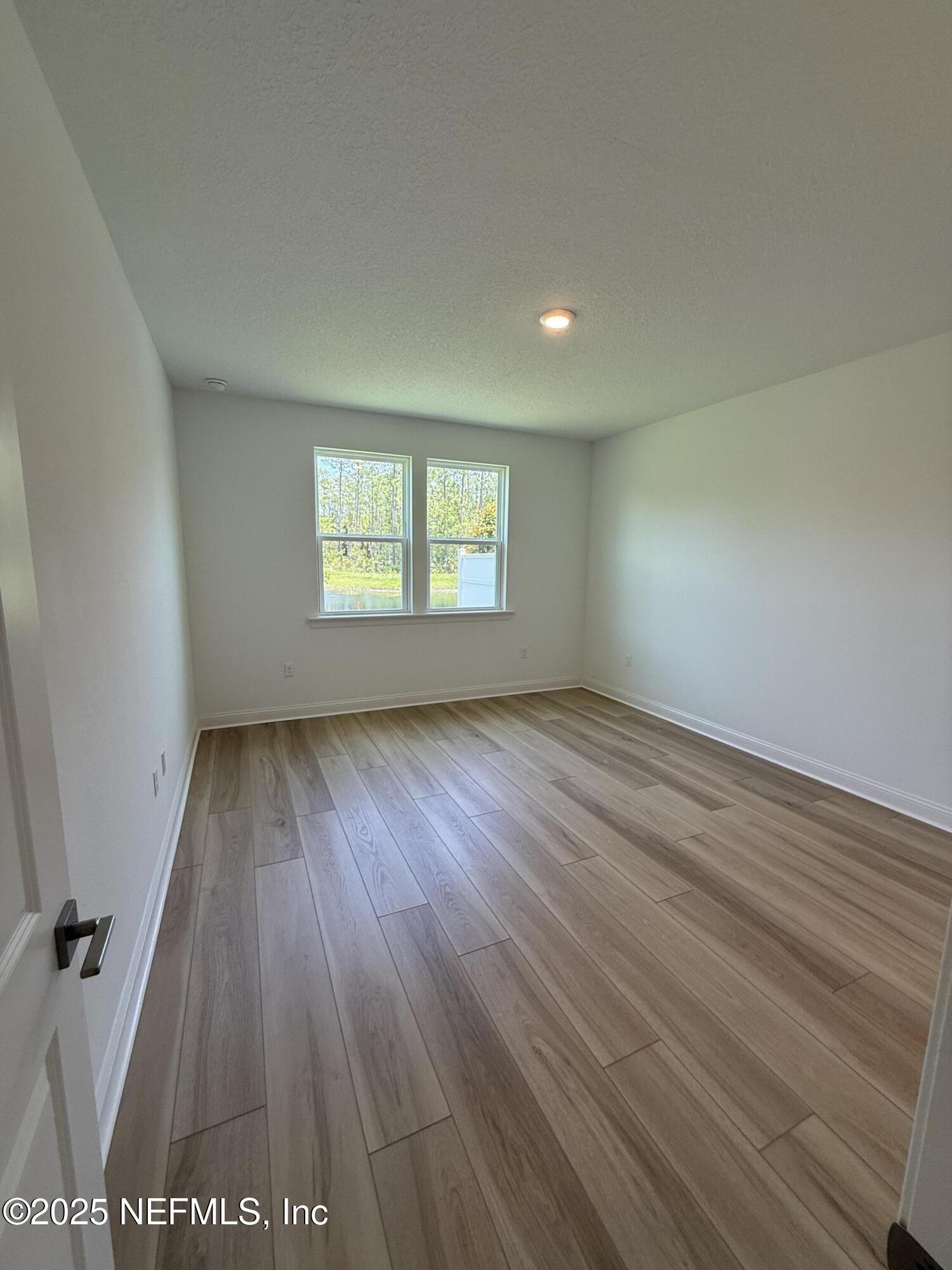 34 Mulberry Road Palm Coast, FL 32164 - Photo 39 of 63 an empty room with wooden floor and windows