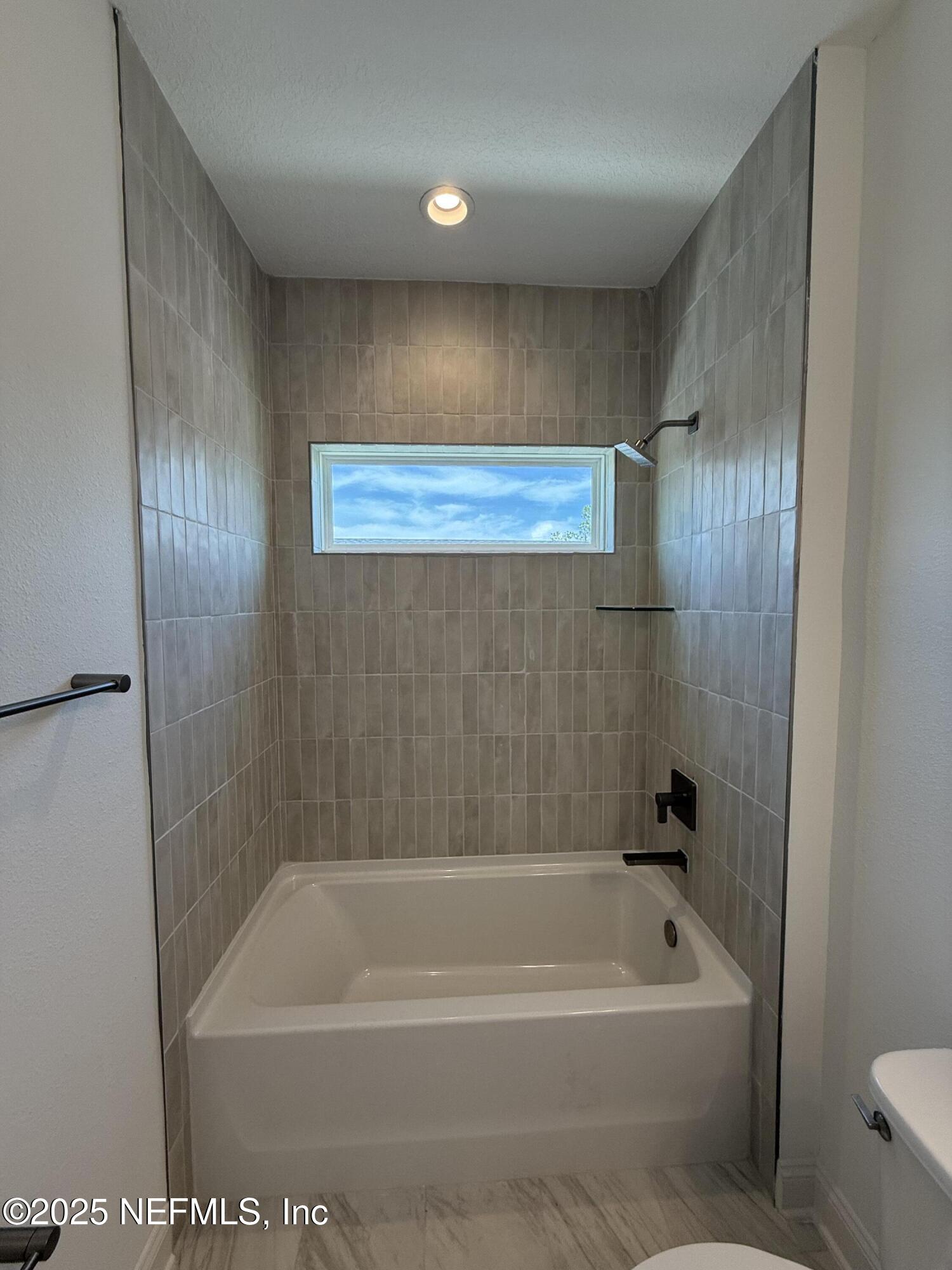 34 Mulberry Road Palm Coast, FL 32164 - Photo 58 of 63 a bathroom with a bathtub and a shower