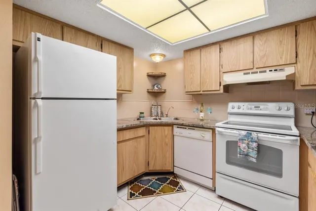 a kitchen with a refrigerator sink stove and cabinets