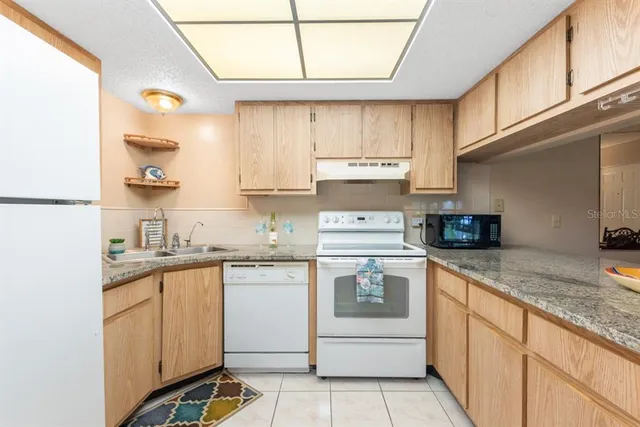 a kitchen with a sink a stove and cabinets