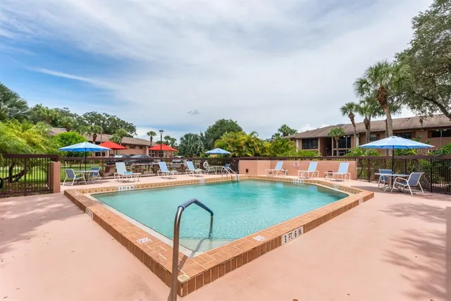 a view of swimming pool with outdoor seating and a garden