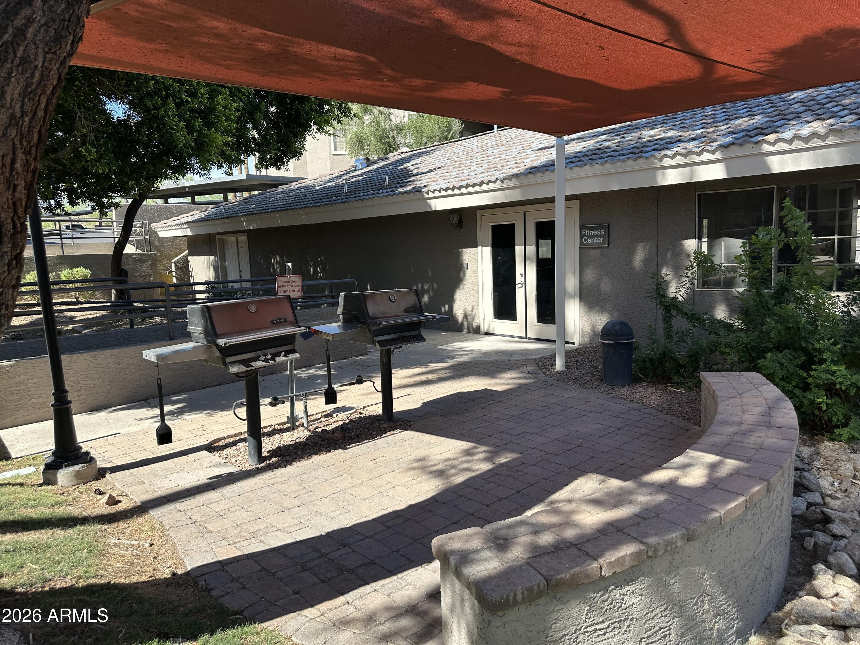 1720 East Thunderbird Road, Unit 1019 Phoenix, AZ 85022 - Photo 46 of 47 a view of a patio with table and chairs with wooden floor and fence