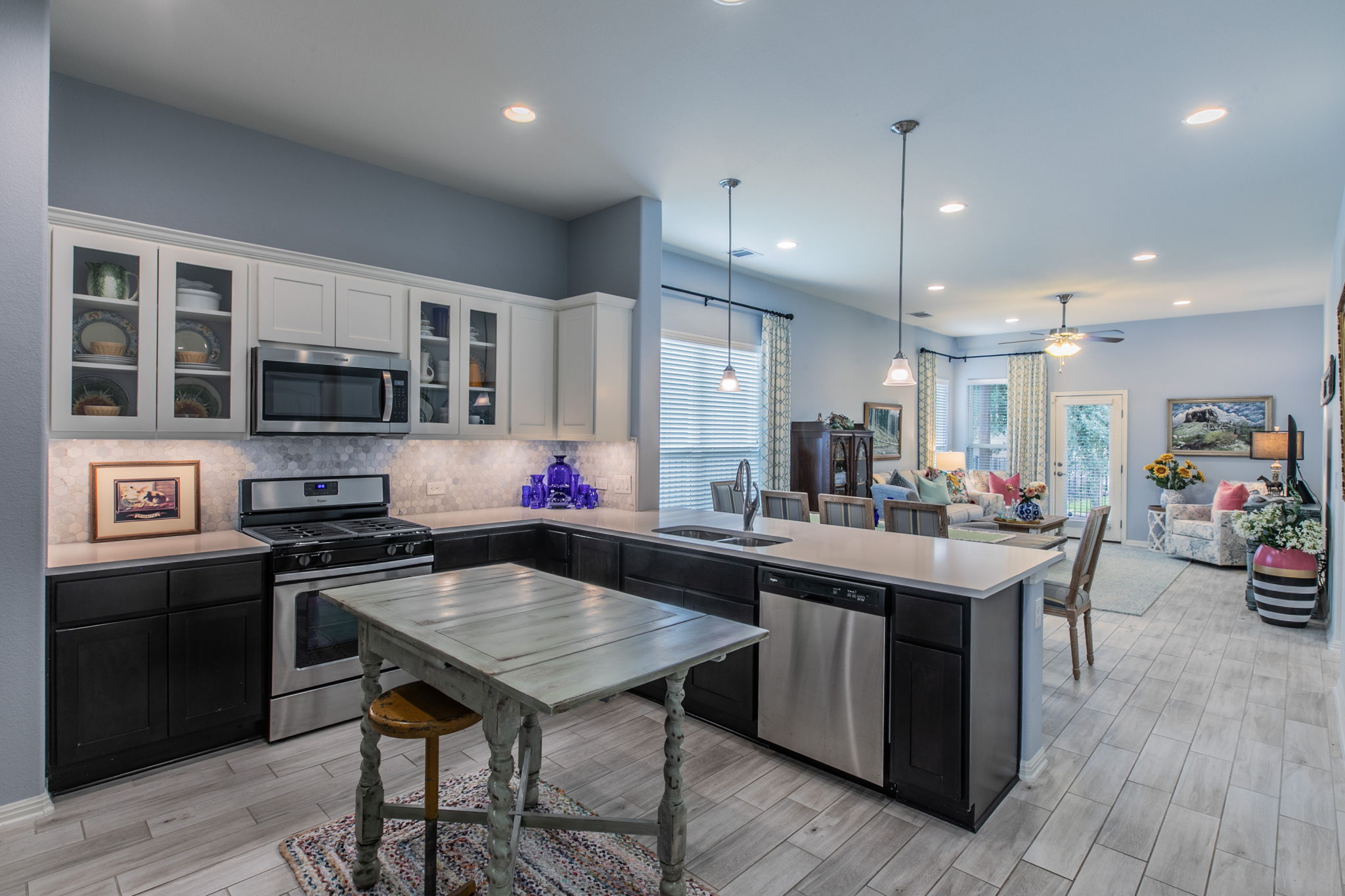 231 Simon Kyle, TX 78640 - Photo 9 of 29 Open-concept kitchen featuring two-tone cabinetry, stainless steel appliances, and light-toned countertops