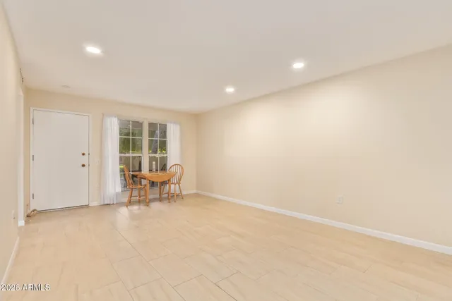 an empty room with chair and a window