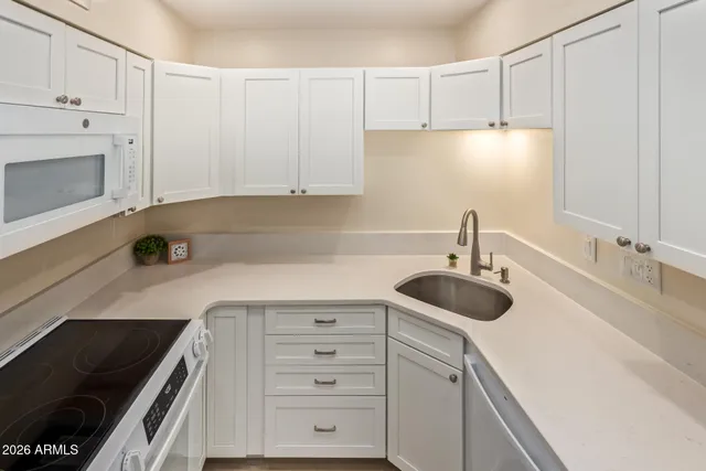 a kitchen with granite countertop a sink stove and cabinets
