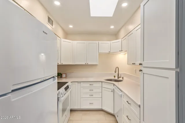 a kitchen with white cabinets and white appliances