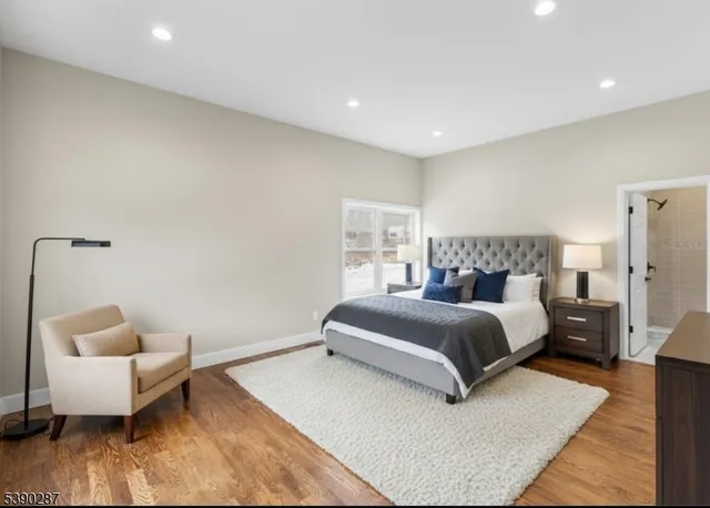 a bedroom with a bed a dresser and a window