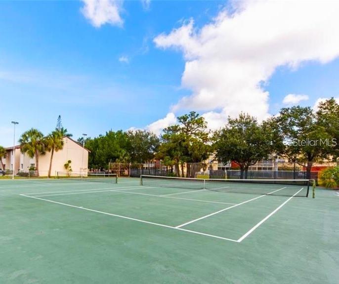 2732C Hidden Lake Boulevard, Unit D Sarasota, FL 34237 - Photo 18 of 19 a view of a tennis ground with large trees