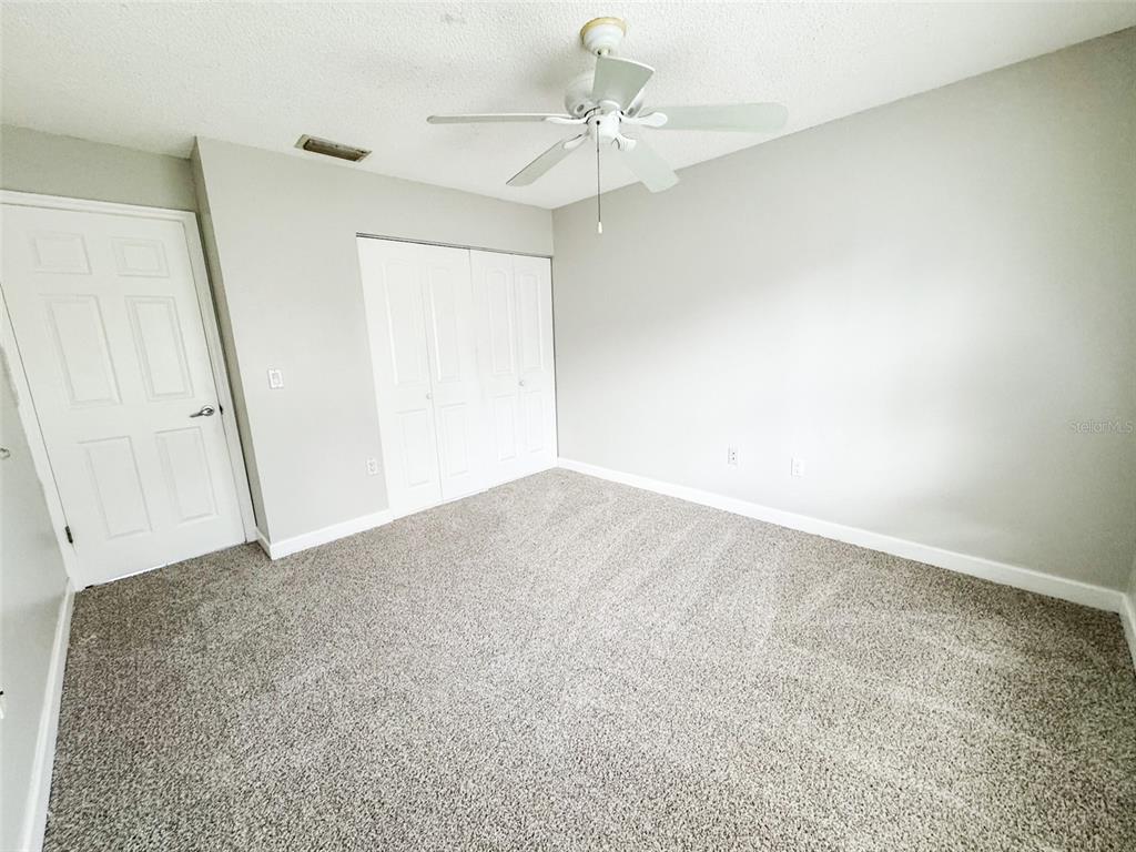 2732C Hidden Lake Boulevard, Unit D Sarasota, FL 34237 - Photo 8 of 19 an empty room with a chandelier fan and windows