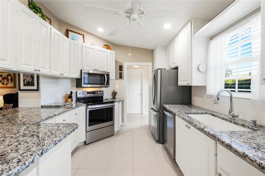3333 Cayman Lane Naples, FL 34119 - Photo 14 of 43 a kitchen with stainless steel appliances granite countertop a sink refrigerator and microwave