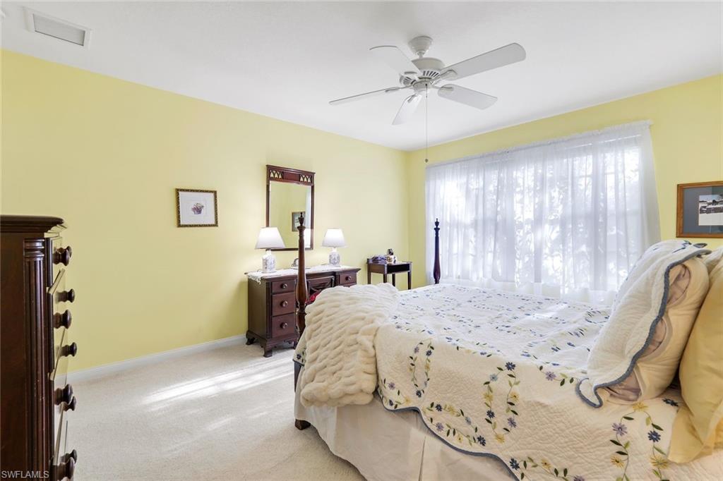 3333 Cayman Lane Naples, FL 34119 - Photo 22 of 43 a bedroom with a bed and a chandelier