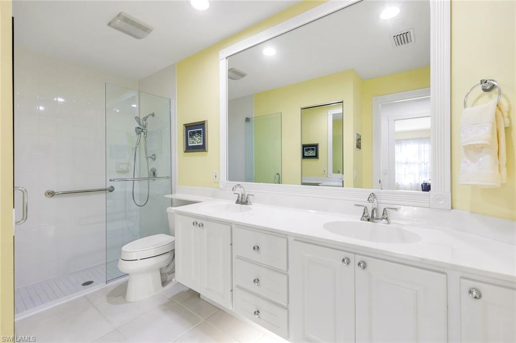 3333 Cayman Lane Naples, FL 34119 - Photo 24 of 43 a spacious bathroom with a double vanity sink toilet mirror and shower