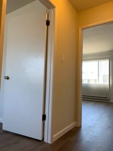 a view of a hallway with a glass door and a bathroom