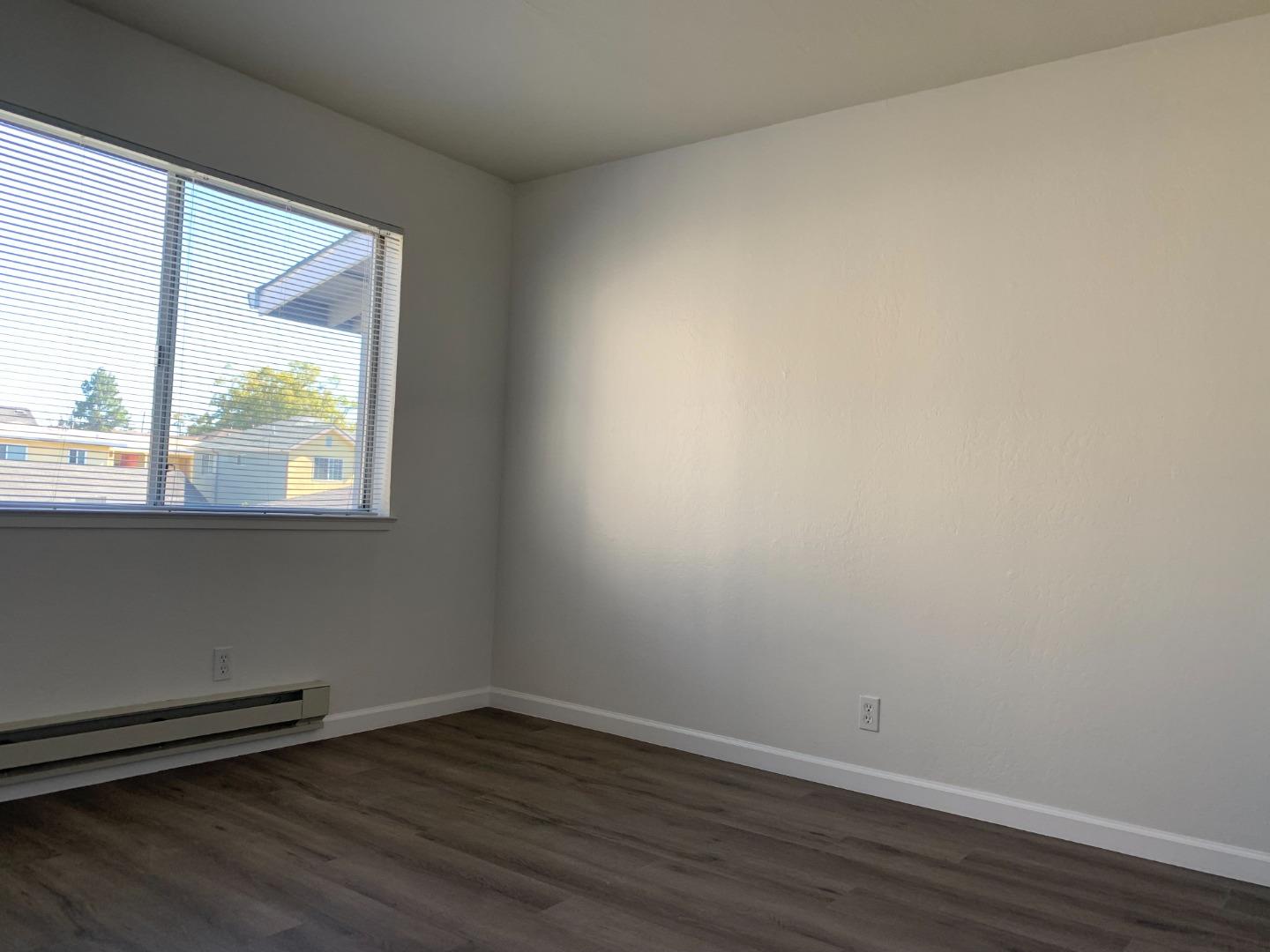729 Highland Avenue, Unit 3 San Mateo, CA 94401 - Photo 12 of 18 a view of an empty room and wooden floor and a window